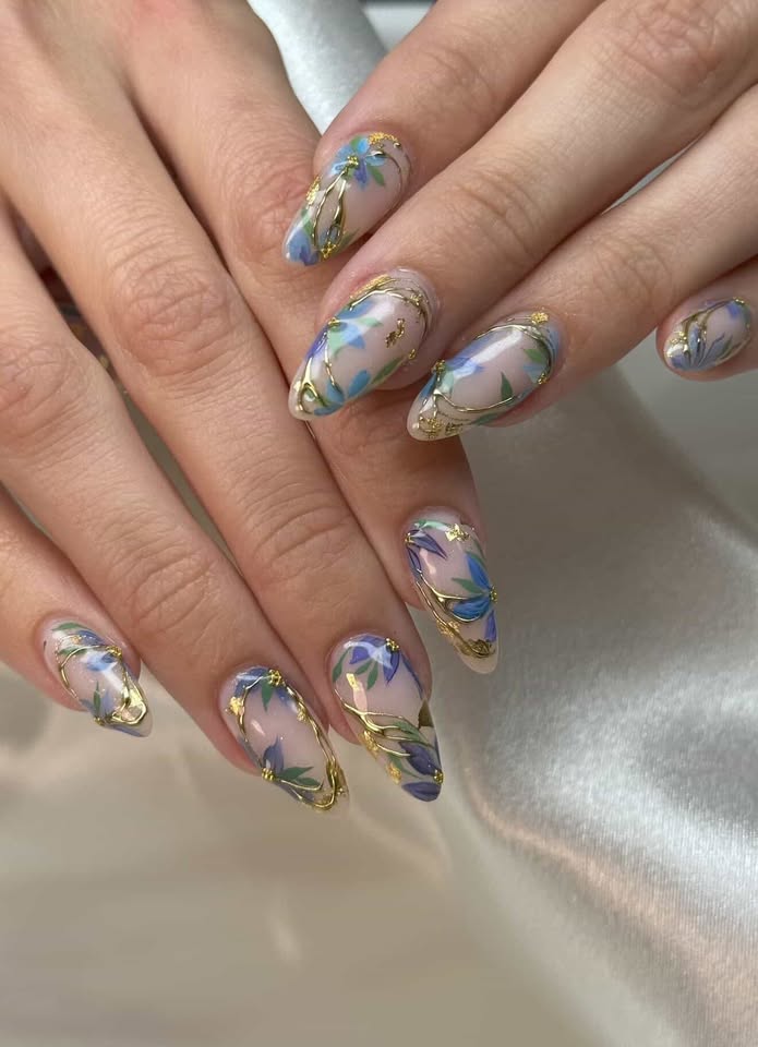 Sheer nails with hand-painted blue florals and gold foil detail