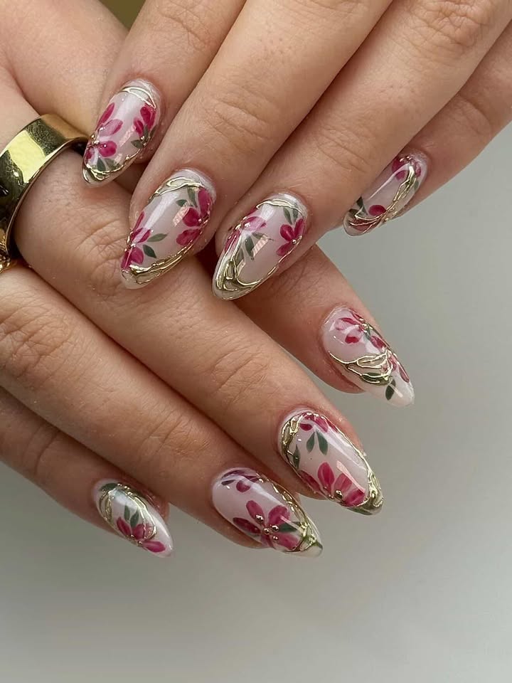 Nude nails with painted red florals and gold chrome frames