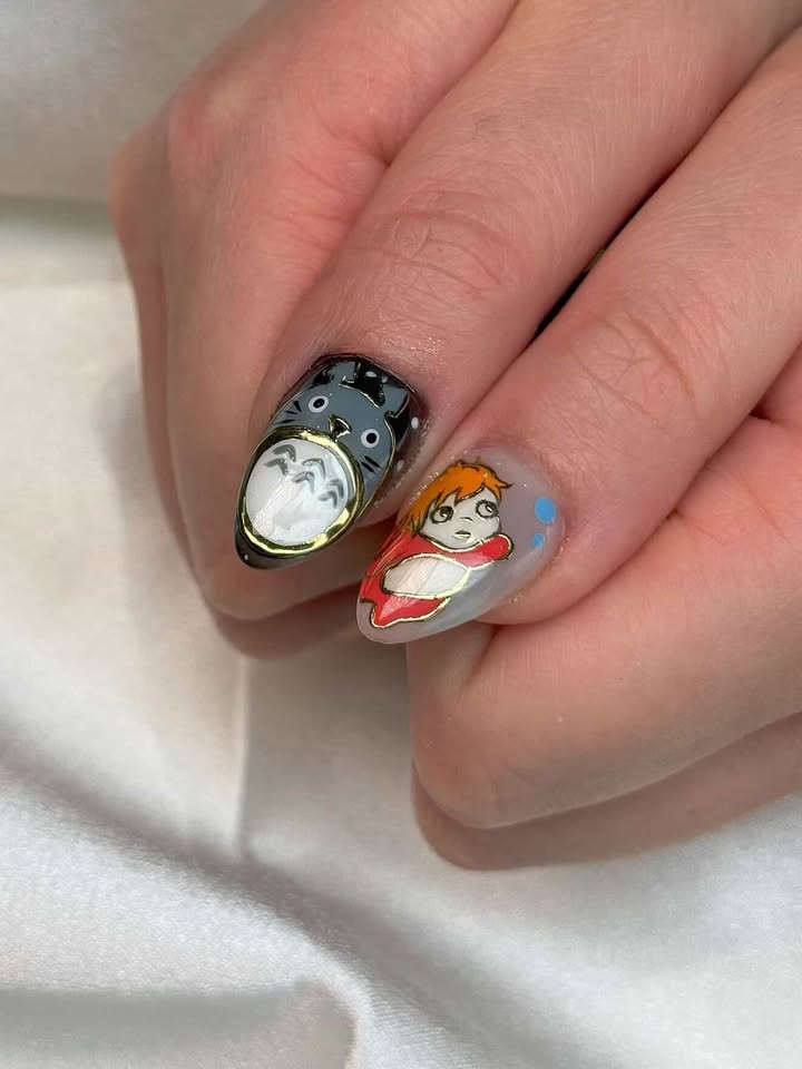Two nails featuring Totoro and Ponyo character art with gold frames